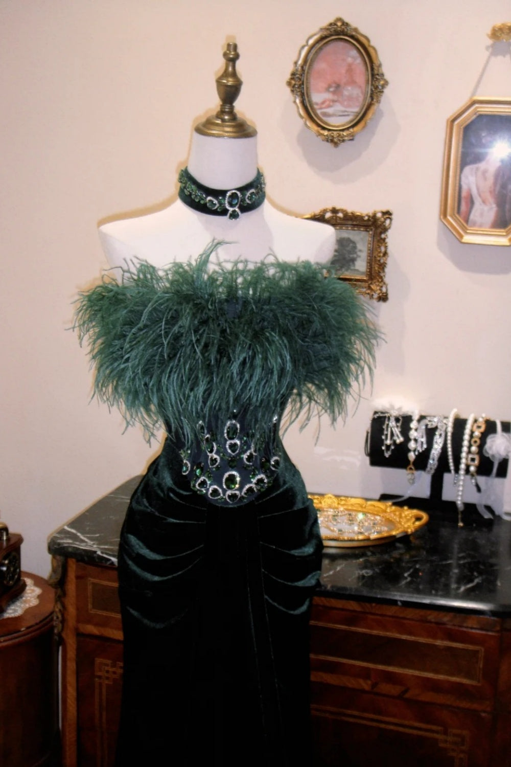 Dunkelgrünes, trägerloses Abendkleid aus Samt mit Federn und hohem Kragen sowie smaragdgrünen Details NV6553