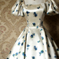 Robe midi bleu satiné à manches bouffantes et col carré, style rétro, idéale pour une soirée légère ou un rendez-vous amoureux (NV6804)